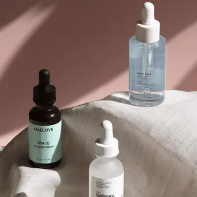 a selection of serums on a pink background