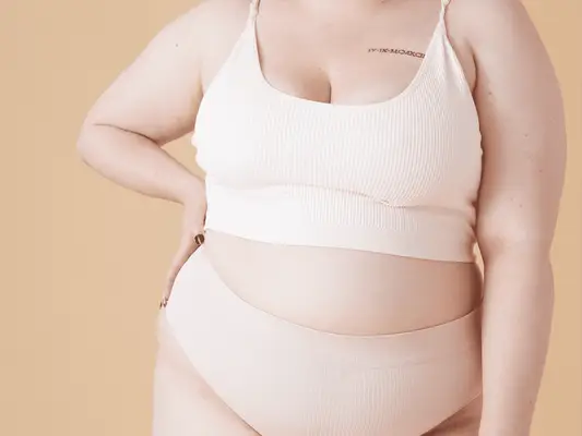 woman posing in cream tank and shorts