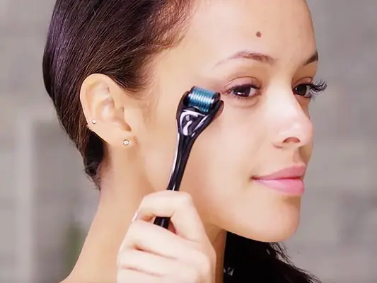 woman using dermaroller on face