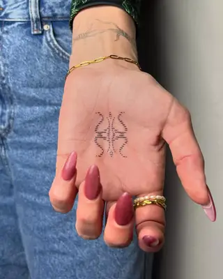 Small flower tattoo on palm of hand
