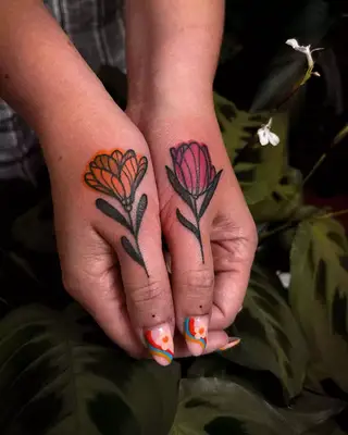 Double flower tattoos on each thumb