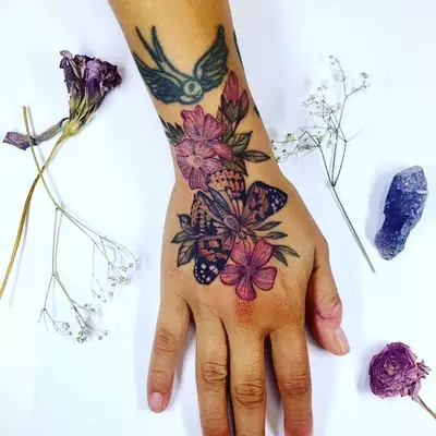 Colorful flowers and butterfly hand tattoo
