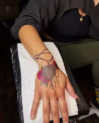Charm bracelet tattoo that wraps around wrist