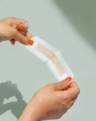 Woman peeling apart wax strip