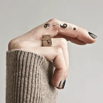Close up of a finger with the deconstructed phases on ying and yang.