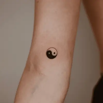 Close up of a ying-yang tattoo with the halves facing each other horizontally. 