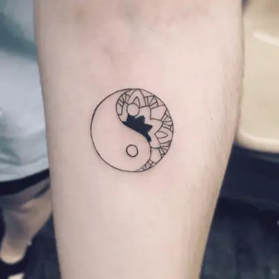 Close up of a yin-yang tattoo with floral outlines.