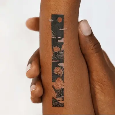 Asian-inspired floral tattoo with red moon on black bar 