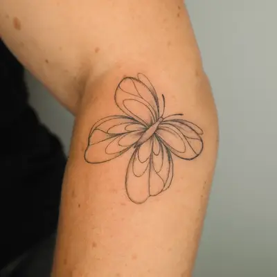 large butterfly tattoo on side of forearm 