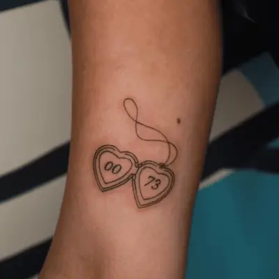 tattoo of heart locket with numbers inside