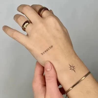 lower case hand tattoo that says 