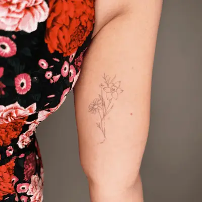 minimal flower greywash tattoos on inner upper arm
