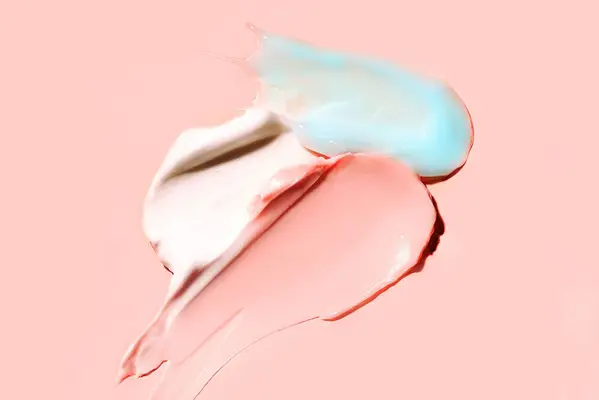 pink, blue, and white creams on pink background