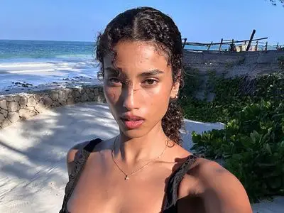 model imaan hammam with glowy skin on a beach