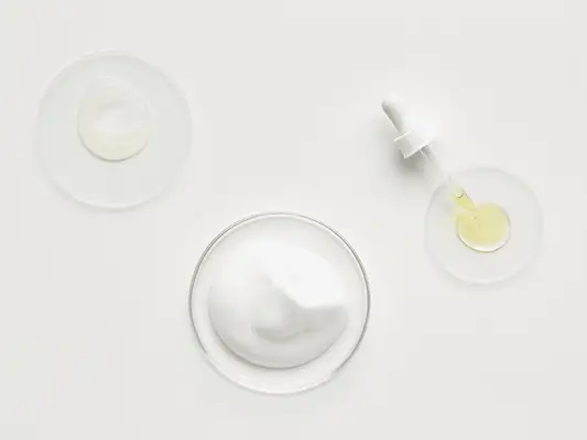 Petri dishes with different skincare products in varying amounts