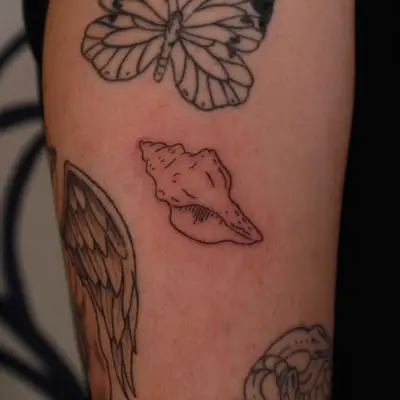 black ink tattoo of small seashell