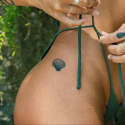 black ink summer seashell tattoo on hip