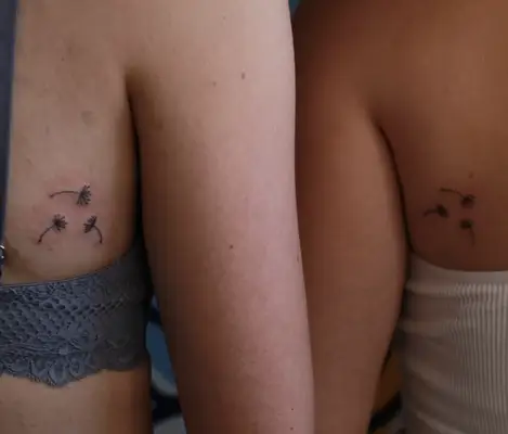 Close up of the back of two arms with to infinity and beyond tattoos