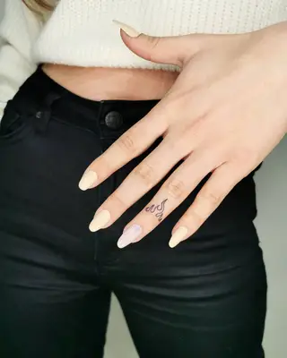 Close up of hand with flame tattoo on ring finger