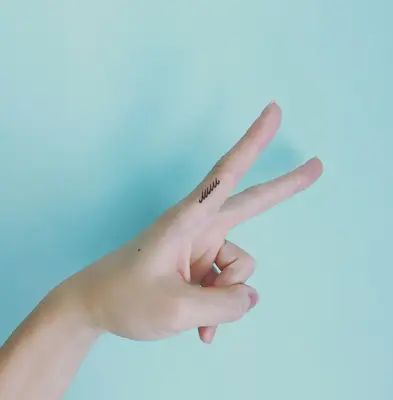 Close up of fingers with scribble tattoo