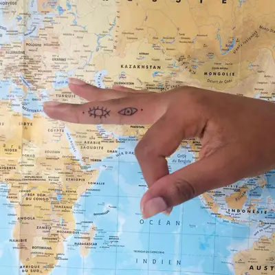 Close up of finger with eye tattoos
