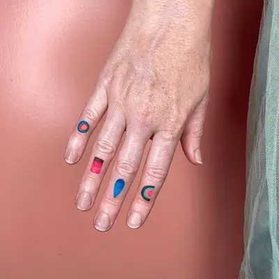 hand with different colorful tattoos on each fin ger