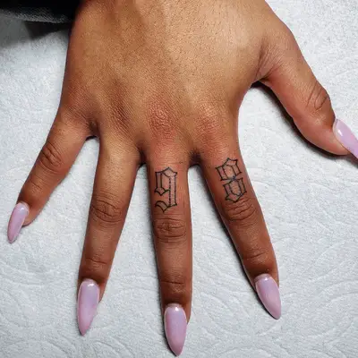 Birth year tattoo on fingers showing the number 98