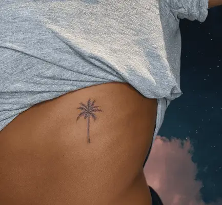 person with small palm tree tattoo on upper ribcage