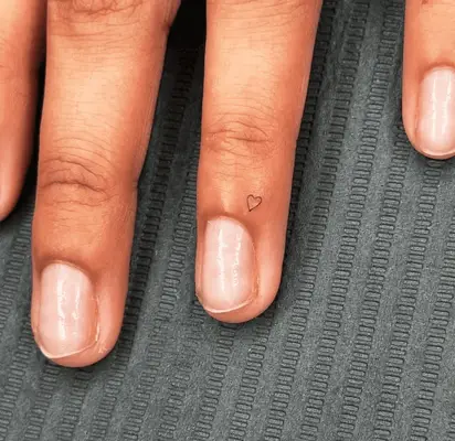 Close up of a small open heart tattoo