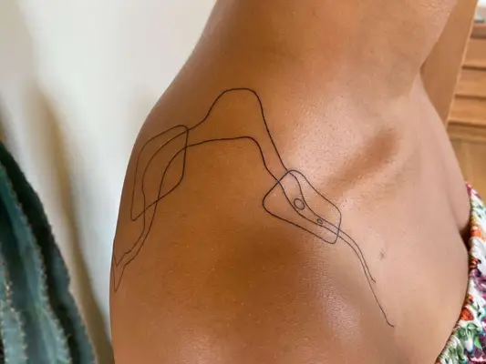 Close-up of shoulder with custom abstract stick-and-poke tattoo design