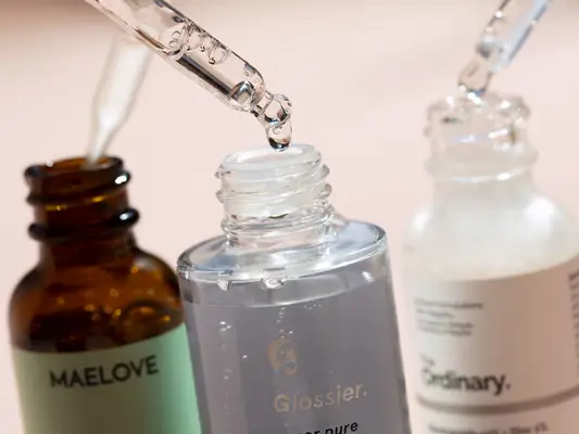Three bottles of niacinamide, droppers held above them