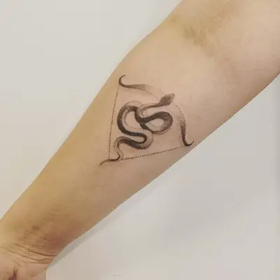 Image of a Sagittarius snake and crossbow tattoo on the forearm