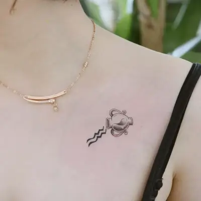 Image of a small Aquarius water pitcher tattoo on a woman