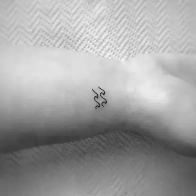Image of an Aquarius wave tattoo on a wrist