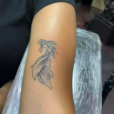 Image of a Pisces fish tattoo on an arm