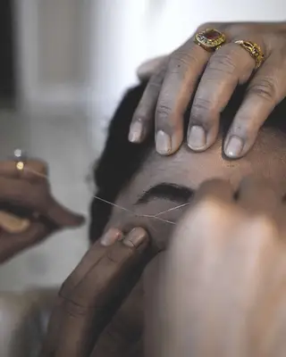 woman getting eyebrows threaded