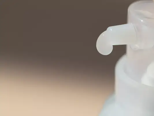 Close up of a drop of product emerging from a bottle