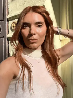 carly cardellino standing in sunlight taking a selfie