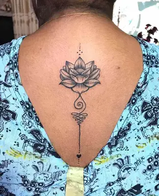 Image of a whimsical black lotus flower tattoo on someone