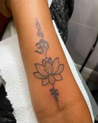 A stemmed lotus flower tattoo on an ankle