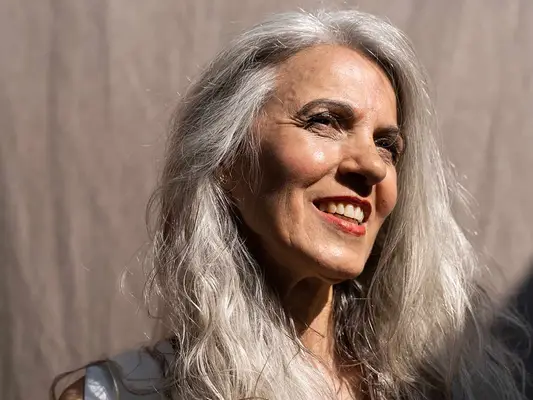 a mature woman smiling in the sunlight