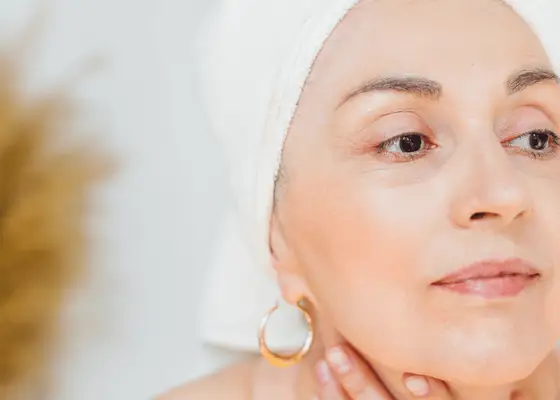 older woman with hair wrapped in white towel 