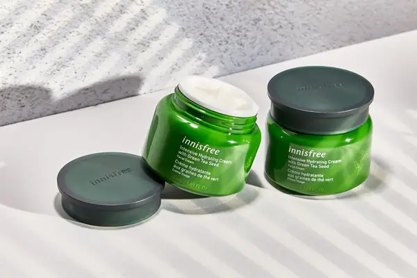 A person dabs moisturizing cream on their face