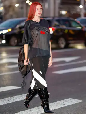 Julia Fox wearing a see-through jersey with basketball shorts and black leather boots