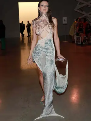 Julia Fox wearing a melting effect top with a blue semi-sheer skirt 