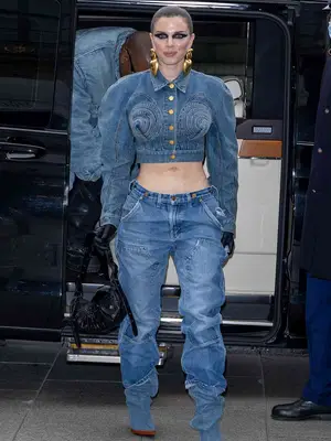Julia Fox wearing a denim jacket with jeans and gold earrings