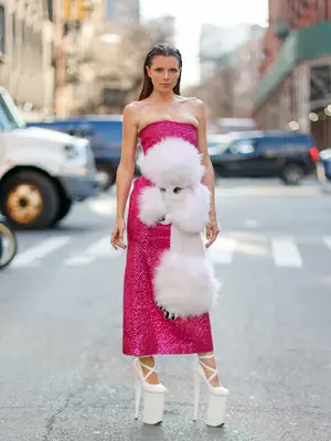 Julia Fox wearing a hot pink strapless dress with a poodle and white platform heels
