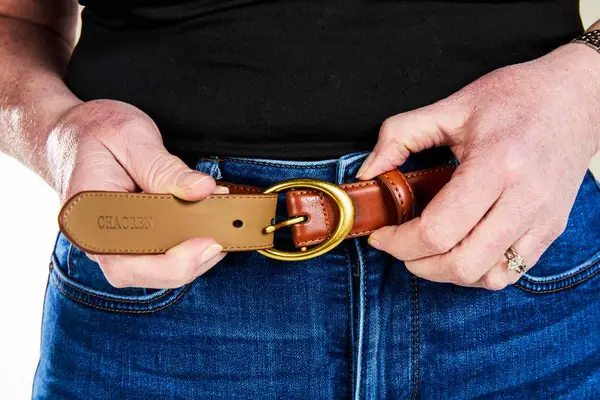 a person adjusting CHAOREN Leather Belt with Gold Buckle
