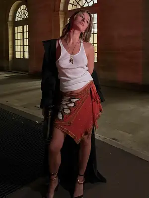 Model wearing a tank top and wrap red skirt with heels