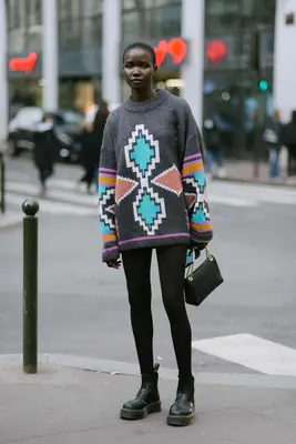 A person wearing an oversized sweater and Dr. Martens. 